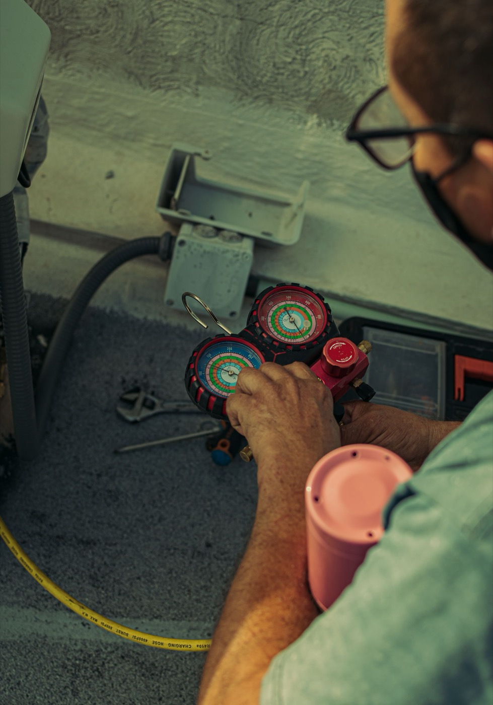 Technician checking the refrigerant lines on an outdoor air conditioning unit
