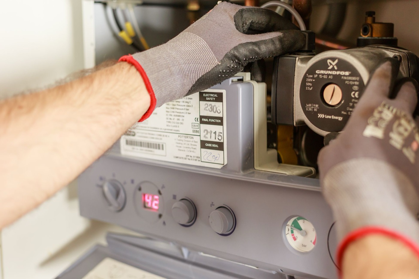 Technician inspecting the burner assembly inside a residential gas furnace